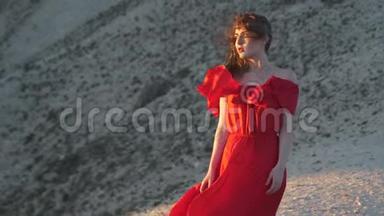 穿红袍的年轻女子望着太阳吹风